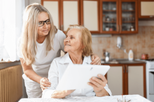 A woman and her mother sit reviewing their choices for aged care near me.